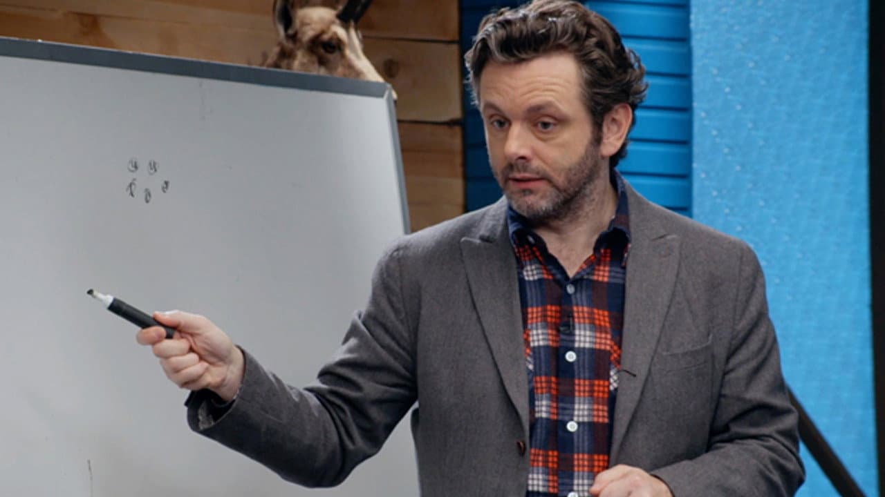Still from Michael Sheen Wears a Plaid Button Down and Grey Blazer